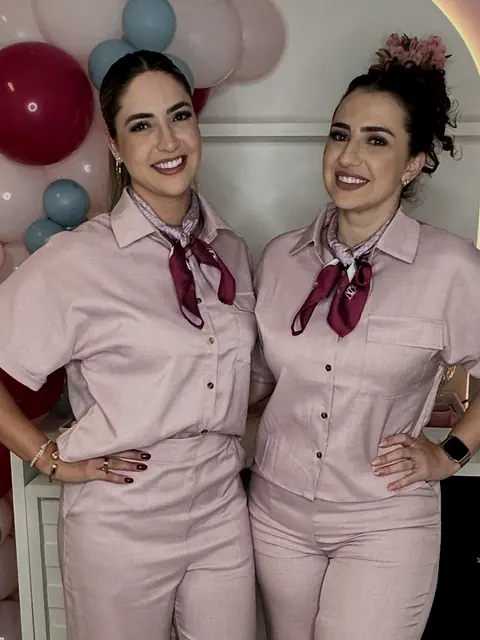 Natália e Andiara de uniforme rosé no salão