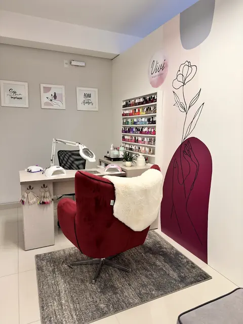 Espaço das unhas com poltrona bordô e mural de flor