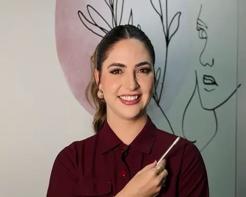 Natália com a caneta de desenho em frente ao mural de traços do rosto