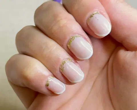 Unhas com esmaltação em gel nude e detalhe dourado