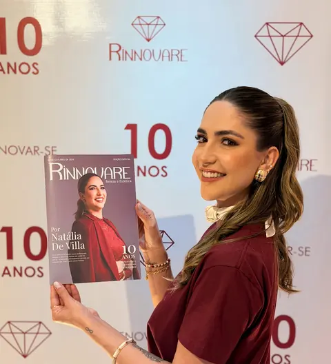 Natália de Villa segurando a revista dos 10 anos da Rinnovare